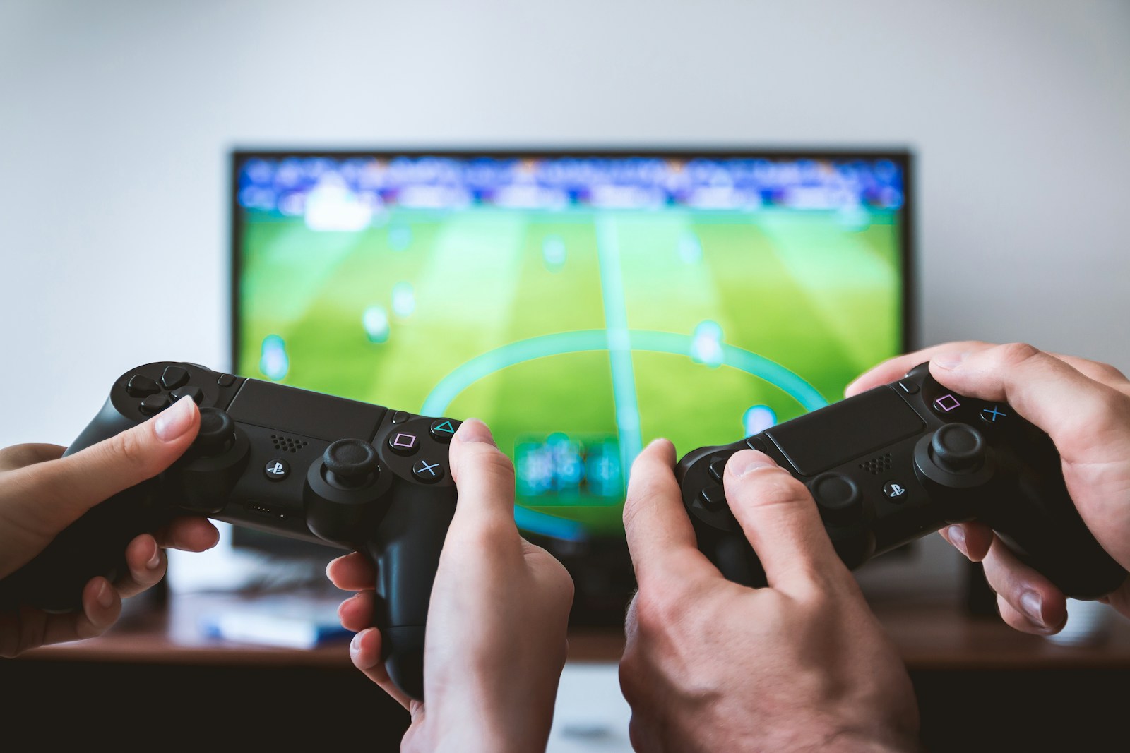 two people playing Sony PS4 game console/JESHOOTS.COM/Unsplash